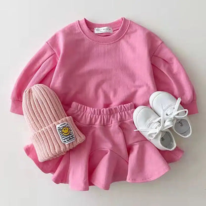 "Conjunto para bebé niña en tonos rosa, compuesto por una camiseta de manga larga y una falda rosa a juego. El conjunto está diseñado con materiales suaves y cómodos para la delicada piel del bebé, ofreciendo un look dulce y elegante. Perfecto para ocasiones especiales o para un día de juego.